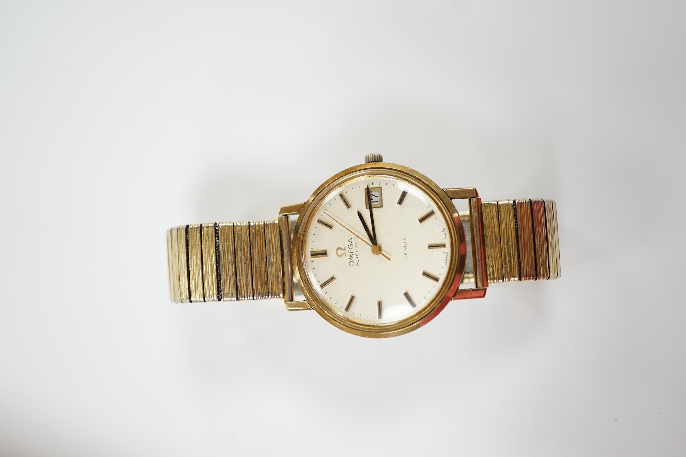 A gentleman's yellow metal Omega De Ville automatic wrist watch, with baton numerals and date aperture, case diameter 34mm, on an associated gold plated bracelet.